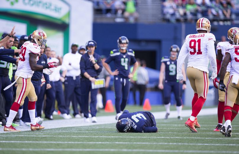 Seattle Seahawks quarterback Russell Wilson stays down after injuring his knee after being tackled by San Francisco 49ers outside linebacker Eli Harold in the second half of the Seahawks’ 37-18 win. (Associated Press)