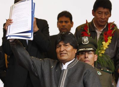 Bolivia’s President Evo Morales shows the new election law to backers in La Paz on Tuesday.  (Associated Press / The Spokesman-Review)