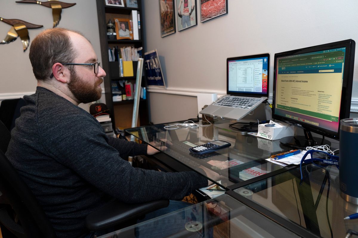 Financial planner Ethan Miller, 30, works on his taxes at his home Friday in Silver Spring, Md.  (Jacquelyn Martin)