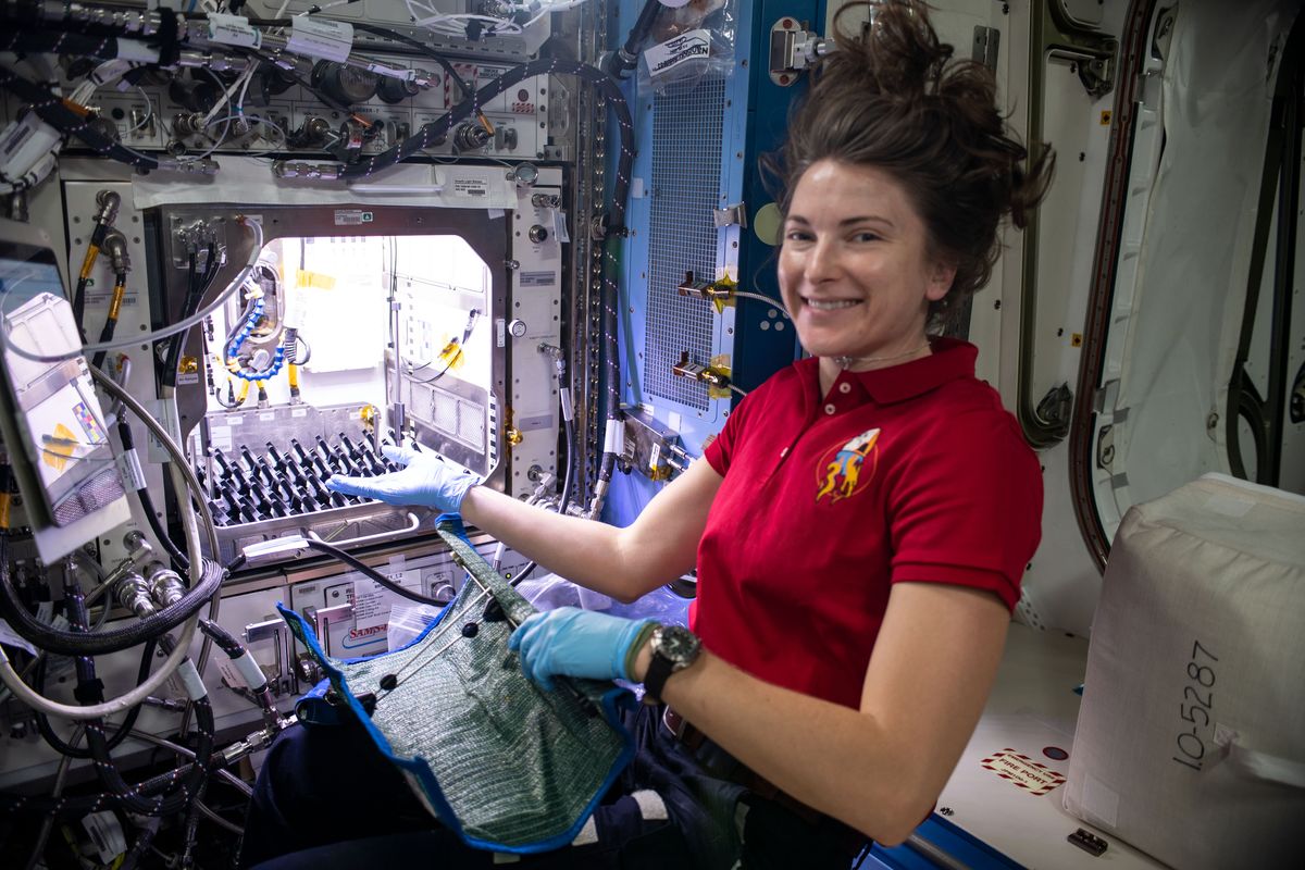 NASA astronaut and Expedition 66 Flight Engineer Kayla Barron sets up the Plant Habitat-05 Growth experiment that is studying cotton genetics in microgravity in this Dec. 27, 2021 photo.  (NASA)