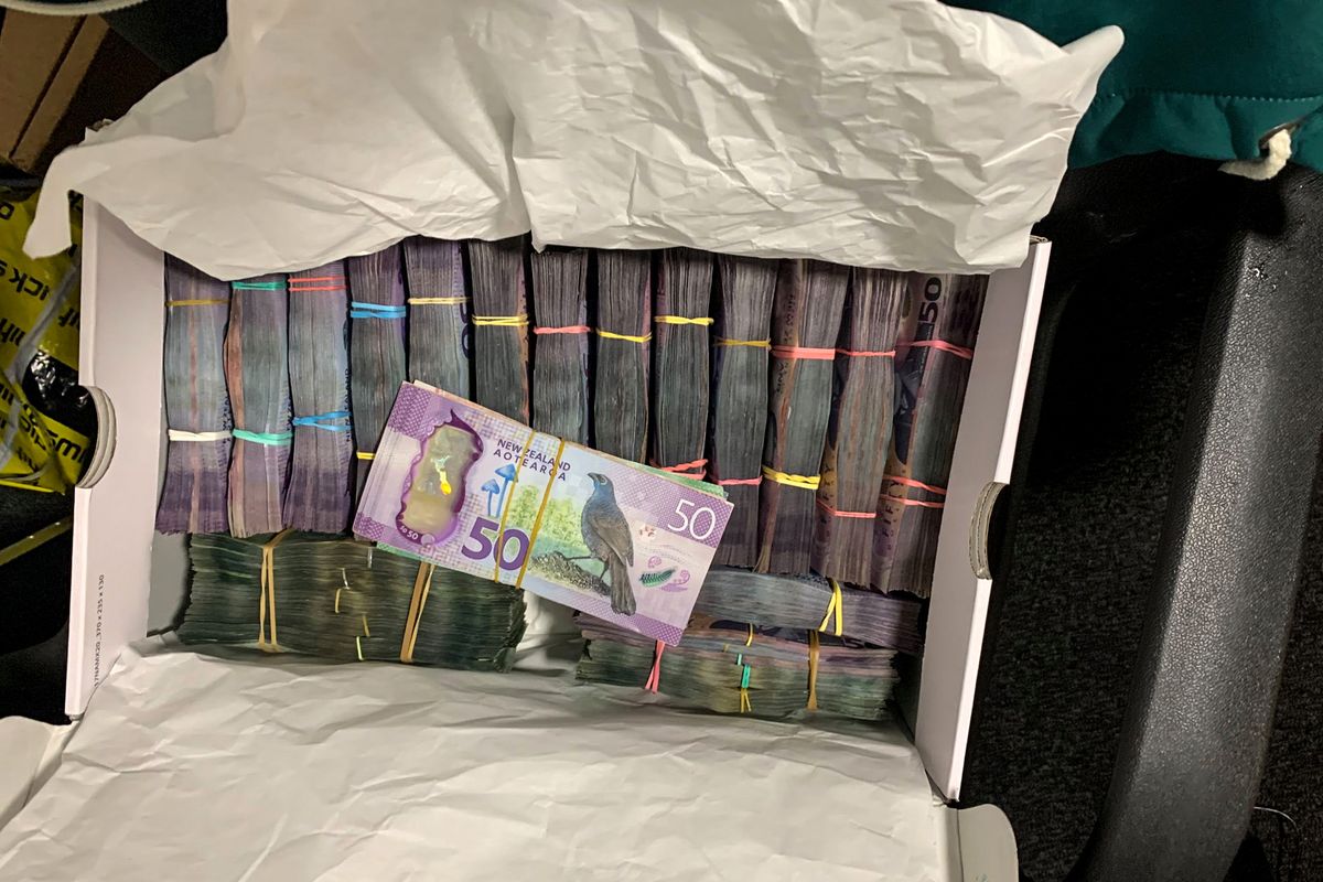 In this undated photo supplied by the New Zealand police, a box containing a large amounts of cash is seen after being discovered during a police raid as part of Operation Trojan. Authorities in Australia and New Zealand Tuesday, June 8, 2021, say they’ve dealt a huge blow against organized crime after hundreds of criminals were tricked into using a messaging app that was being secretly run by the FBI.  (NZ Police)