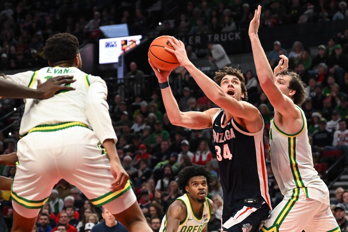 Gonzaga Bulldogs forward Braden Huff (34) moves to the hoop and scores against Oregon Ducks center Nate Bittle (32) during the second half of a college basketball game on Sunday, Dec 21, 2025, at Moda Center in Portland, Ore. Gonzaga won the game 91-82. (Tyler Tjomsland / The Spokesman-Review)