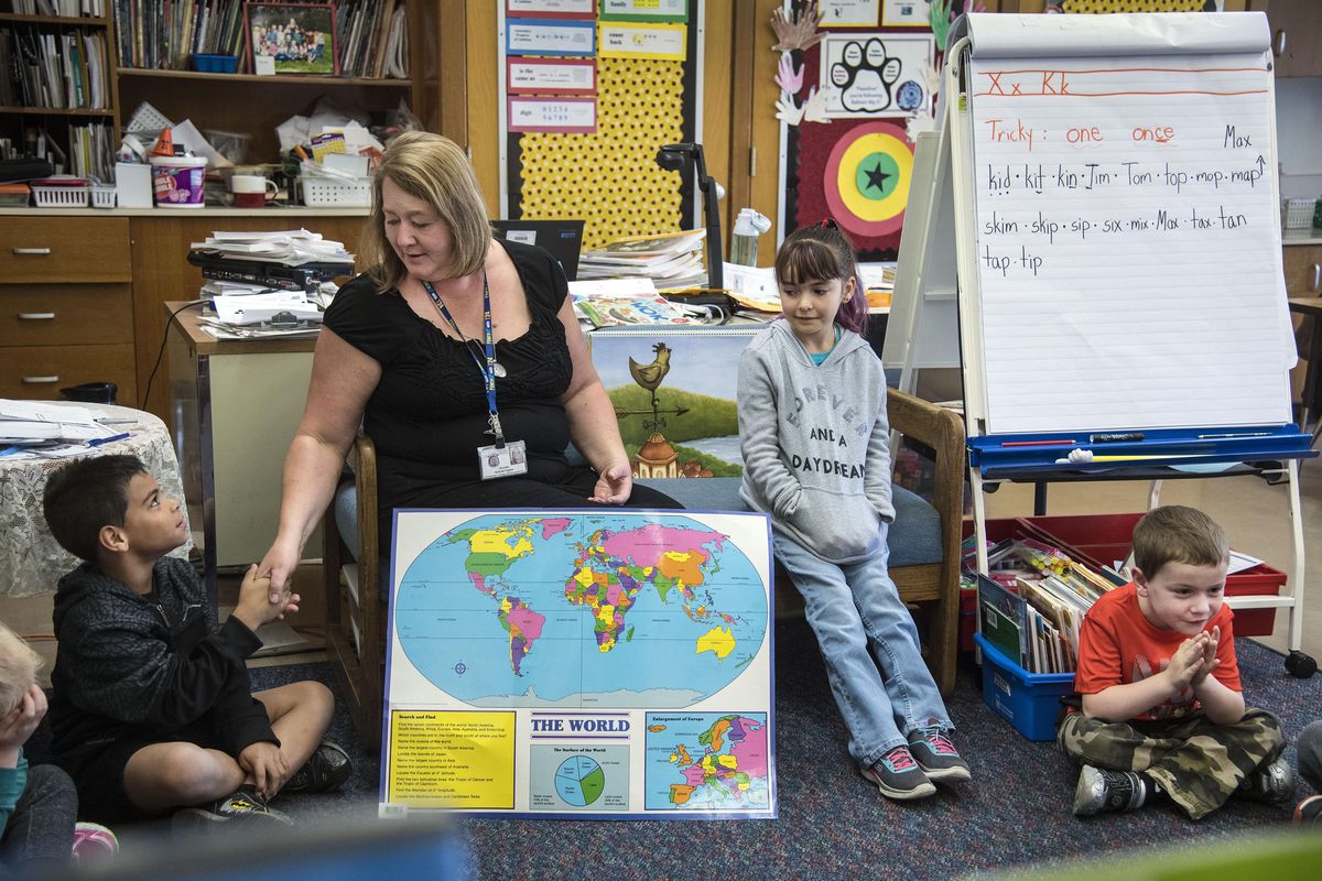 Balboa Elementary School first-grade teacher Rene Bettinson greets student Quentin Carroll as they learn about Japan to open the school day, Sept,. 23, 2016, in Spokane, Wash. Gabriella Sanchez Astroga and Brandon Whetham, right, had already given their greetings. Bettinson and her students are participating in the new curriculum know as Core Knowledge. (Dan Pelle / The Spokesman-Review)