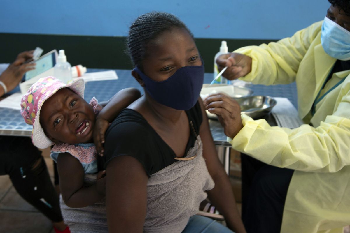 FILE - A baby cries as her mother receives her Pfizer vaccine against COVID-19, in Diepsloot Township near Johannesburg Thursday, Oct. 21, 2021. A new COVID-19 variant has been detected in South Africa that scientists say is a concern because of its high number of mutations and rapid spread among young people in Gauteng, the country