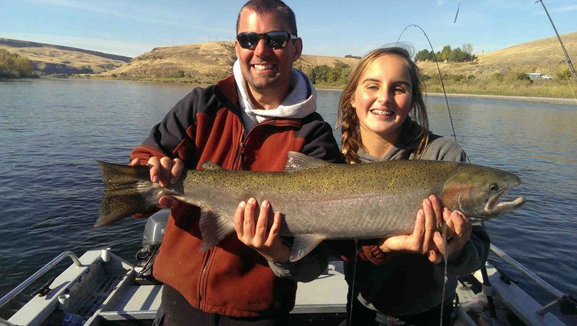 Reel Time Fishing guide Travis Wendt of Lewiston helps hold a steelhead caught by Cassidy Hegland of Ten Mile, Tenn., while fishing the Clearwater River in October.
 (Reel Time Fishing)