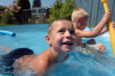 
Blake Rose, 6, and his brother Donovan, 5, keep cool in a backyard pool set up by their grandmother on Wednesday in Post Falls. The city set a water usage record during last week's heat wave, pumping more than 85 million gallons. Coeur d'Alene also pumped about 85 million gallons last week.
 (Jesse Tinsley / The Spokesman-Review)