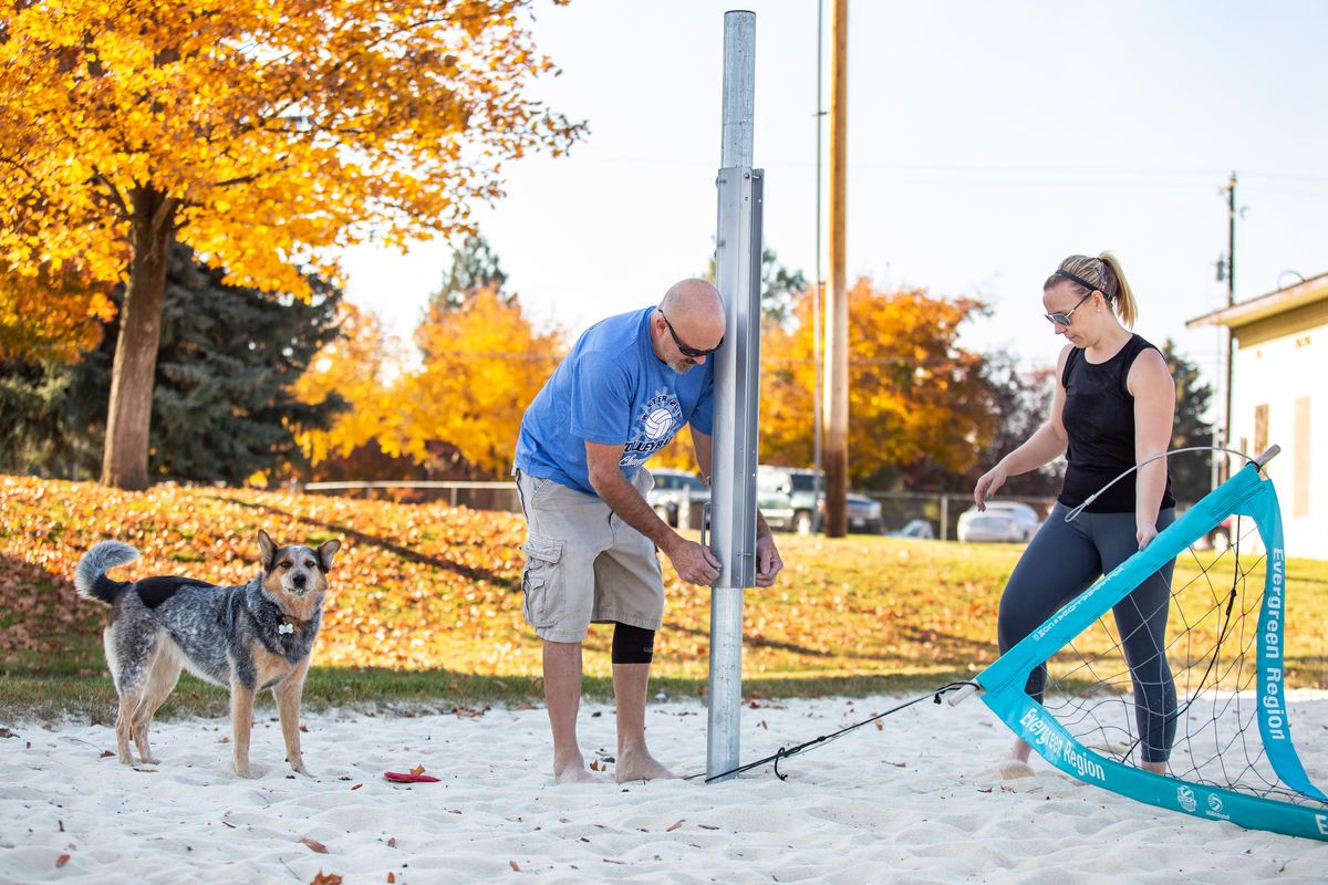 Volunteer Dennis Baal (center) and Lindsay Callaghan, operations manager for Evergreen Regional Volleyball Association (right) take down volleyball nets at Browns Park in Spokane Valley, Wash., on Oct. 22, 2018. Once updates and renovations are complete, the park will have 16 sand volleyball courts in total, a pickleball court, a larger parking lot and more space for picnic shelters. (Libby Kamrowski / The Spokesman-Review)