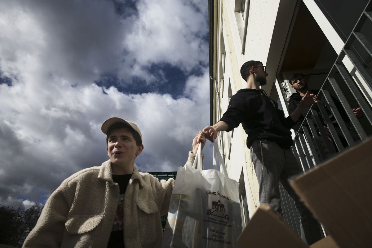 From left, Danya, 21, Gabriel, 21 and Borden, 17 all refugees from Odesa, Ukraine help to deliver bags with food to needy people during preparations for the celebration of Jewish Passover at the Chabad Jewish Education Center in Berlin, Germany, Thursday, April 7, 2022. Rabbis and Jewish organizations are working round the clock within Ukraine, Eastern Europe and other parts of Europe to make sure that Jews who remain in Ukraine and refugees who have fled as far away as Israel are able to celebrate Passover.  (Markus Schreiber)