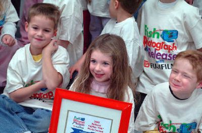 
Brooklyn Cunningham poses with her Skyway Elementary classmates, and shows off the award she won from Fujifilm, recognizing her for a fishing photo and essay she entered in a contest. 
 (Jesse Tinsley / The Spokesman-Review)