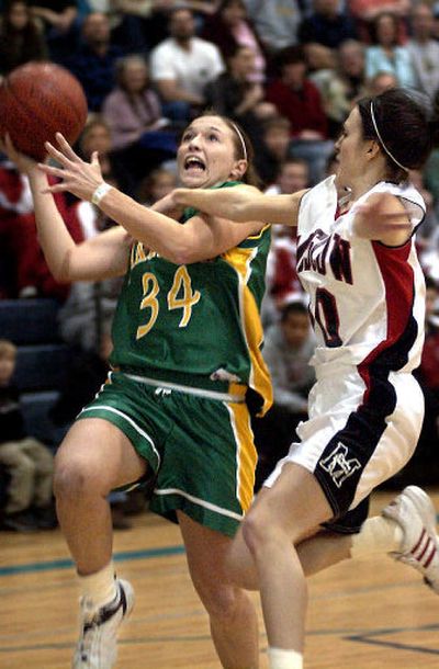 
Lakeland's Kayla Stiegemeier, left, drives past Moscow's Molli Lee-Painter on Saturday. 
 (Tom Davenport / The Spokesman-Review)
