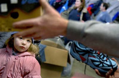 
Four-year-old Emily Sweitzer watches as shoes are given away during Homeless Connect at the Idaho National Guard Armory in Post Falls last month. She is not homeless but her family is having a tough time making it through the winter, and showed up to receive some help. 
 (Kathy Plonka / The Spokesman-Review)