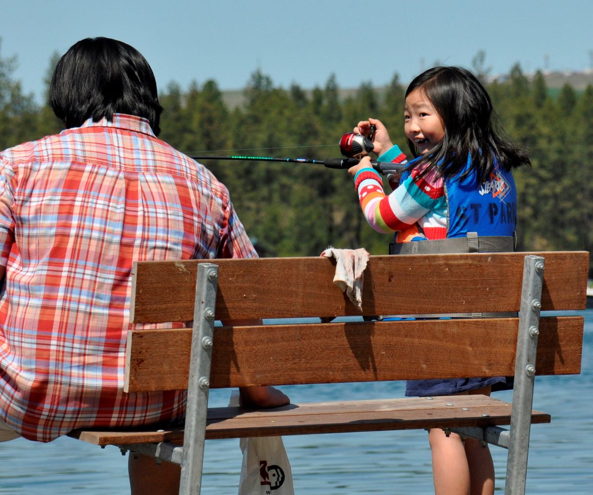 A girl hooks her first fish at the Kid Fishing Day on Clear Lake, Saturday, May 2, hosted by Washington Department of Fish and Wildlife and dozens of volunteers from area sporting groups. (Rich Landers)