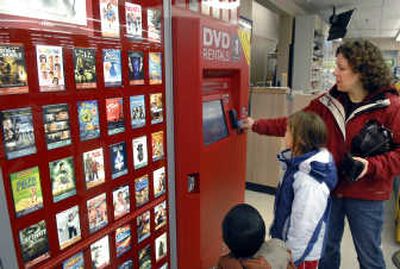 
Kim Powell and her children Anna, 7, and Sam, 6, find a Barbie movie at the Redbox in Albertsons on 37th and Grand. 
 (Dan Pelle / The Spokesman-Review)
