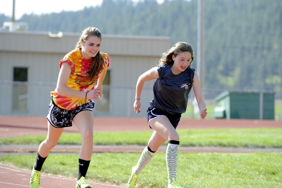 East Valley’s Alyssa Harmon, left, and Brittany Aquino work out side-by-side on the EVHS track  May 2, 2013. Harmon, now a distance runner at Northwest Christian College in Eugene, credited Aquino for making her a better 800-meter runner that season. (Jesse Tinsley / The Spokesman-Review)