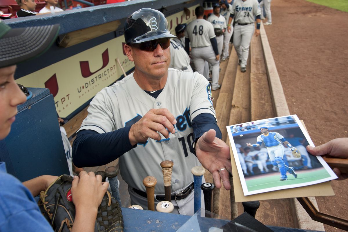 Former Mariners catcher Dave Valle, in his first year as a minor league manager with Everett, signs autographs at Avista Stadium. (Dan Pelle)