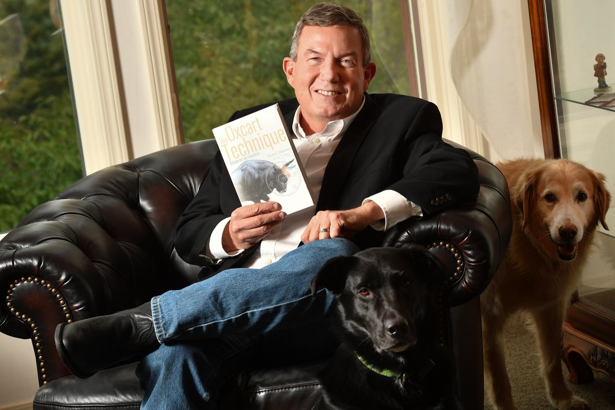 Spokane Valley’s Terry Fossum poses for a photo on Friday, Oct. 28, 2022, with his book, “The Oxcart Technique.” The book has reached No. 1 on the Wall Street Journal, Barnes & Noble and Amazon lists, and made USA Today’s Top 50 list.  (Tyler Tjomsland/The Spokesman-Review)