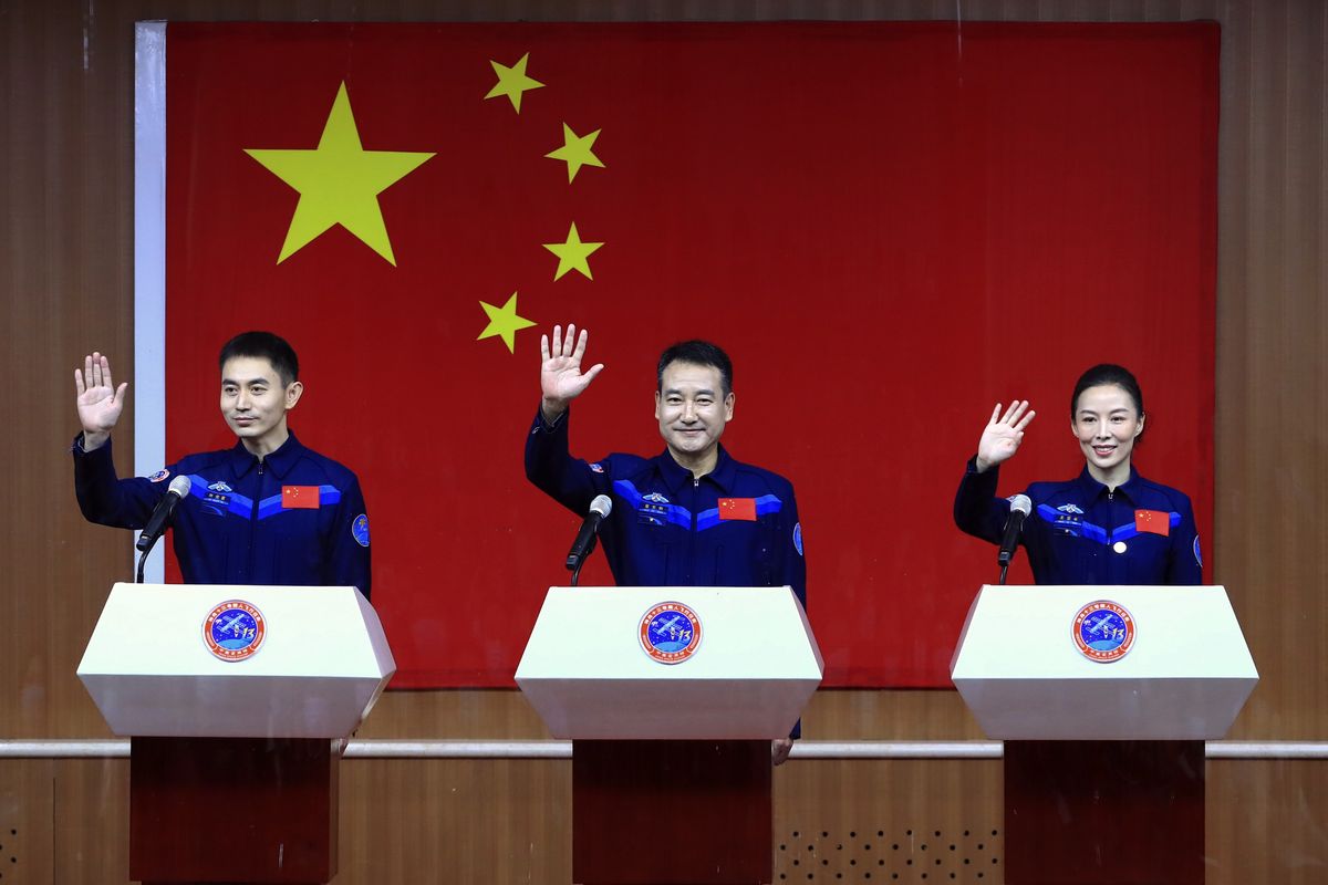 In this photo released by Xinhua News Agency, Chinese astronauts, from left, Ye Guangfu, Zhai Zhigang and Wang Yaping wave to reporters as they arrive for a press conference at the Jiuquan Satellite Launch Center ahead of the Shenzhou-13 launch mission from Jiuquan in northwestern China, Thursday, Oct. 14, 2021. China is preparing to send three astronauts to live on its space station for six months — a new milestone for a program that has advanced rapidly in recent years.  (Ju Zhenhua)