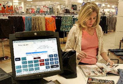 
A customer looks at a catalog next to a screen that can order merchandise online at a JC Penney's store in a Fricso, Texas. 
 (Associated Press / The Spokesman-Review)