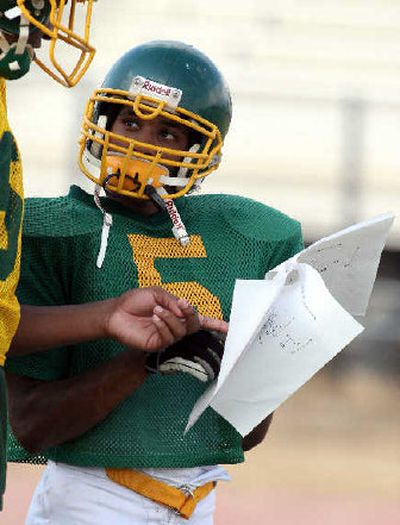 
Senior Mike William, of New Orleans, goes over the new playbook at Madison High in Dallas. 
 (Associated Press / The Spokesman-Review)