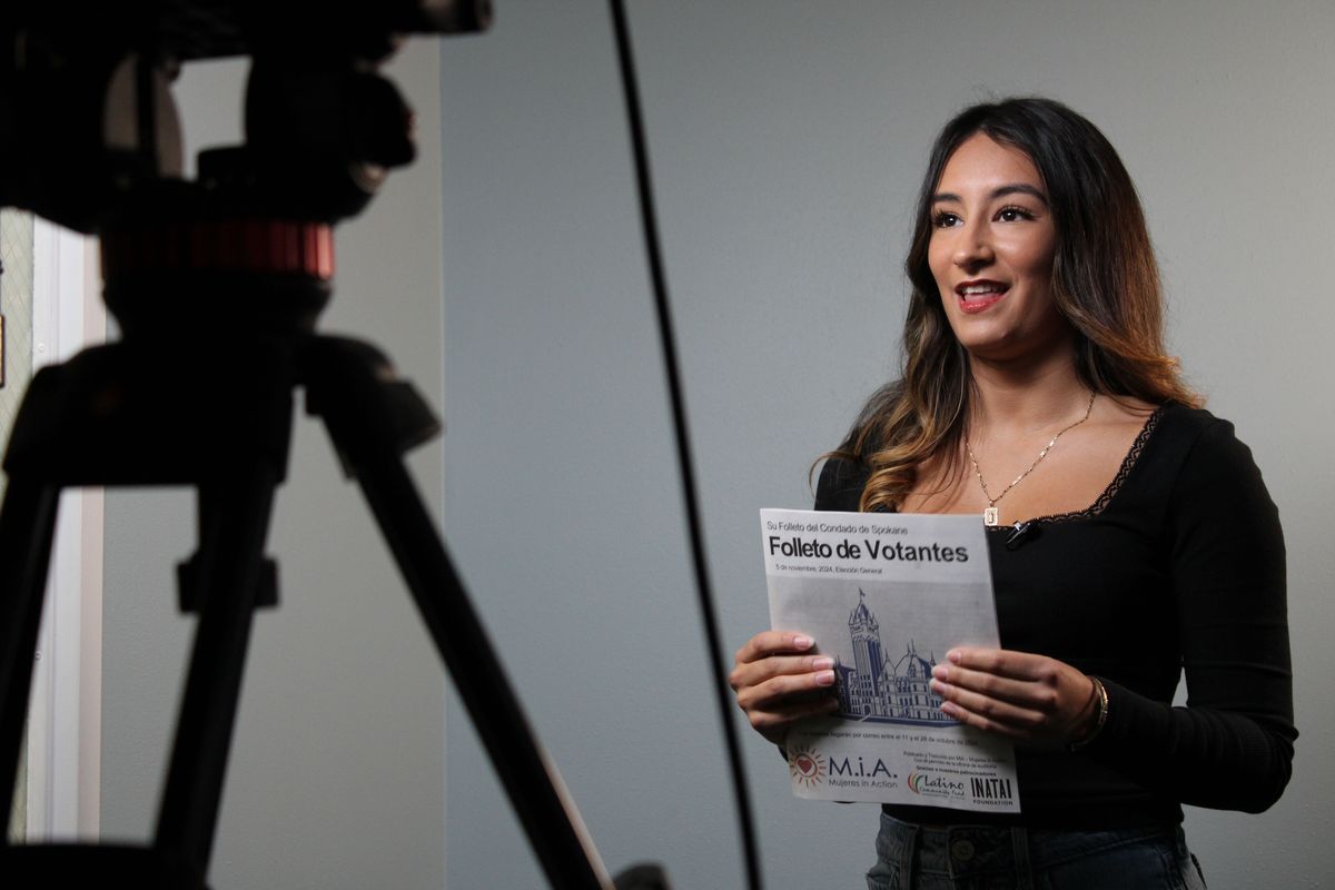 Jacquelyn Garcia-Angulo, community organizer of Mujeres in Action, holds up a translated voter pamphlet Wednesday while filming an informative video on the importance of voting.  (Monica Carrillo-Casas/The Spokesman-Review)