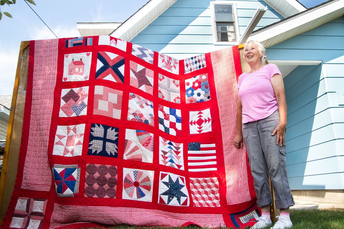 Laurienne Newell shows off the large quilt she began restoring in April and completed this month.  (Libby Kamrowski/ THE SPOKESMAN-REVIEW)