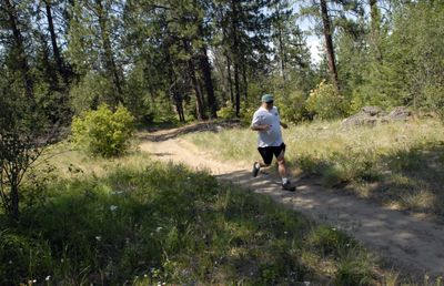 A man jogs through the Dishman Hills Natural Area. Beginning in 1966, land was purchased and donated to protect the Dishman Hills from urban sprawl and development. A gently rolling trail system passes outcroppings of 1.5 million-year-old layered rocks, ponds, grasslands, shrublands and forests. (J. BART RAYNIAK / The Spokesman-Review)