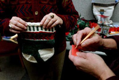 
Fay Wright sells raffle tickets at NIC's Student Union Building for the knit stockings and socks that she made to benefit Heifer International.
 (The Spokesman-Review)