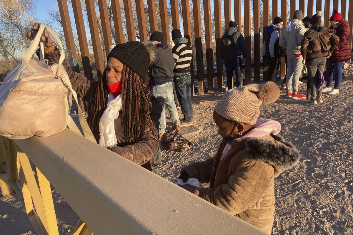 A Cuban woman and her daughter wait in line to be escorted to a Border Patrol van for processing in Yuma, Ariz., Sunday, Feb. 6, 2022, hoping to remain in the United States to seek asylum. For nationalities that don
