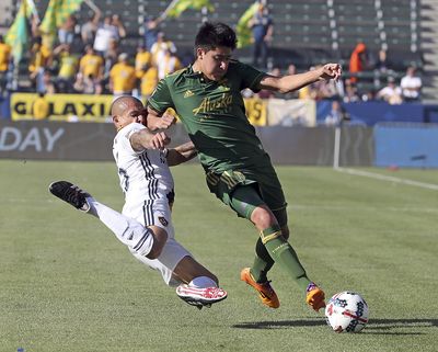 In this March 12, 2017, file photo, Portland Timbers defender Marco Farfan, right, and LA Galaxy midfielder Rafael Garcia tangle during the first half of an MLS soccer match in Carson, Calif. Farfan spends a lot of time during the week wrapping up his senior year at Centennial High School just east of Portland. Weekends are a whole different matter. The 18-year-old defender is playing for the Timbers, and is the first Homegrown Player developed by the team’s academy system. (Reed Saxon / Associated Press)