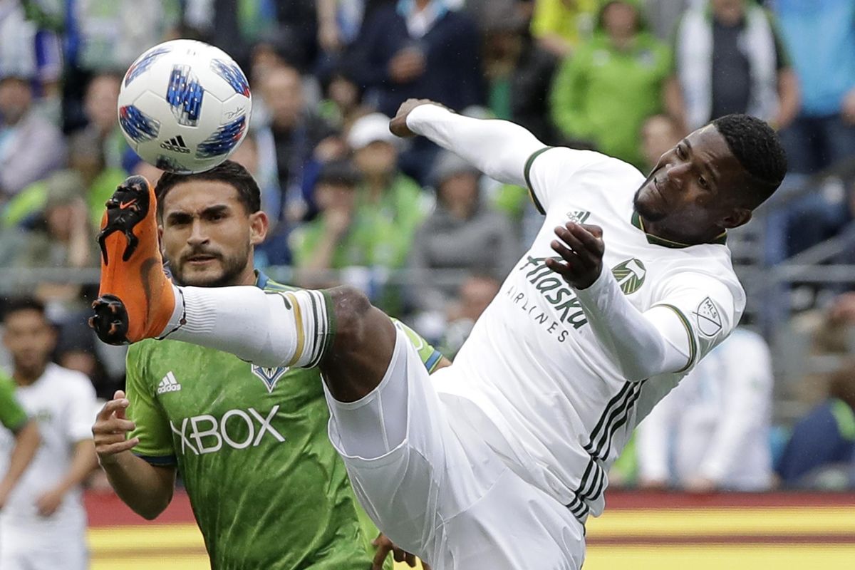In this June 30, 2018 file photo, Portland Timbers midfielder Dairon Asprilla, right, kicks the ball in front of Seattle Sounders midfielder Cristian Roldan, left, during the first half of an MLS soccer match in Seattle. (Ted S. Warren / Associated Press)