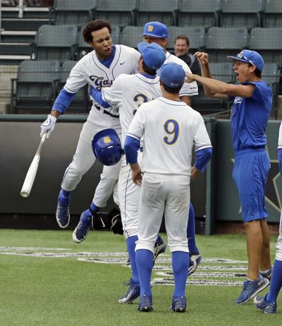 UC Santa Barbara’s Devon Gradford, top left, celebrates with teammates after hitting a home run against Washington in the 12th inning to tie the game at 2. (Mark Humphrey / Associated Press)