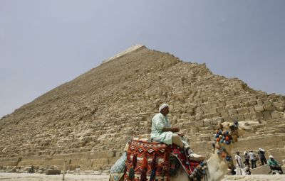 An Egyptian camel rider waits for customers at the site of the ancient Giza Pyramids in Cairo.  (Associated Press / The Spokesman-Review)