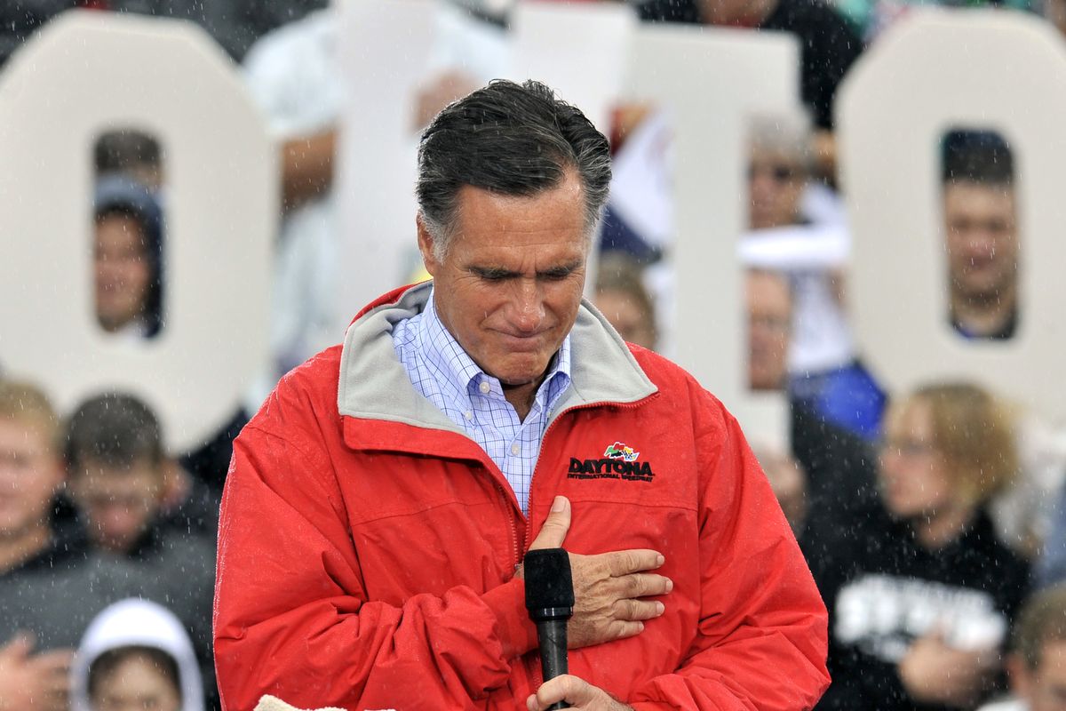 Republican presidential candidate, former Massachusetts Gov. Mitt Romney puts his hand on his heart during a moment of silence for the embassy officials killed in Libya, as he campaigns in the rain at Lake Erie College in Painesville, Ohio, Friday, Sept. 14, 2012. (David Richard / Fr25496 Ap)