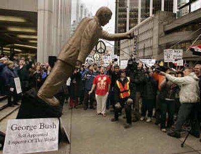 
Mimicking the pulling down of the statue of Saddam Hussein during the Iraq war, more than 500 protesters cheer as a mock statue of President Bush is pulled down outside the U.S. consulate in downtown Vancouver, B.C., on Tuesday. 
 (Associated Press / The Spokesman-Review)