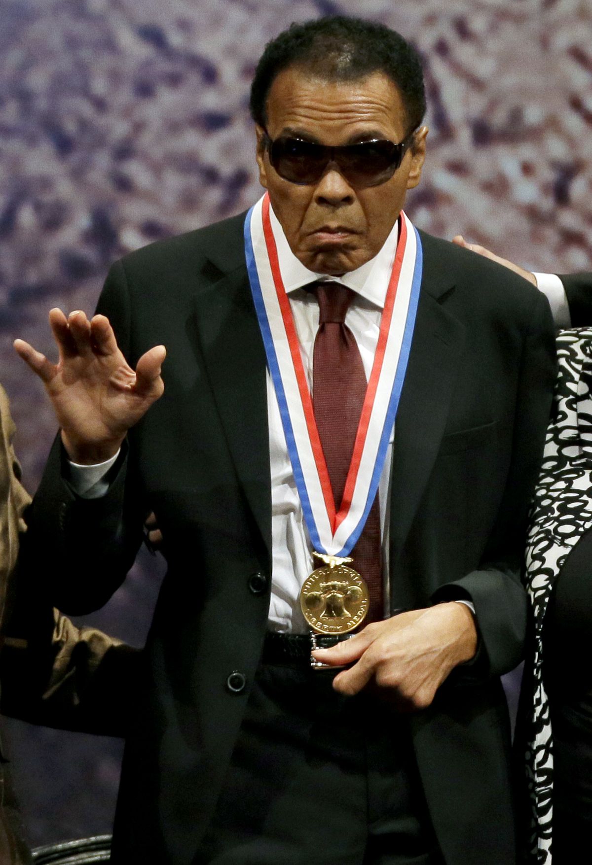 Retired boxing champion Muhammad Ali waves after receiving the Liberty Medal during a ceremony at the National Constitution Center, Thursday, Sept. 13, 2012, in Philadelphia. The honor is given annually to an individual who displays courage and conviction while striving to secure liberty for people worldwide. (Matt Slocum / Associated Press)