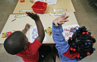 
Marvin Domino, left, and Aronele Baldwin raise their hands at Alice Harte Elementary charter school in New Orleans on  Sept. 12.
 (Associated Press / The Spokesman-Review)