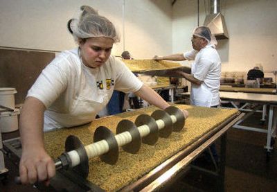 
Tarra Chapman, cuts a sheet of chai-with-almond Bumble Bars at Bumble Bar, Inc., located in the Spokane Business and Industrial Park. Bumble Bar makes gluten and dairy-free energy bars and operates in 3,200 square feet of space.
 (Photos by Liz Kishimoto / The Spokesman-Review)