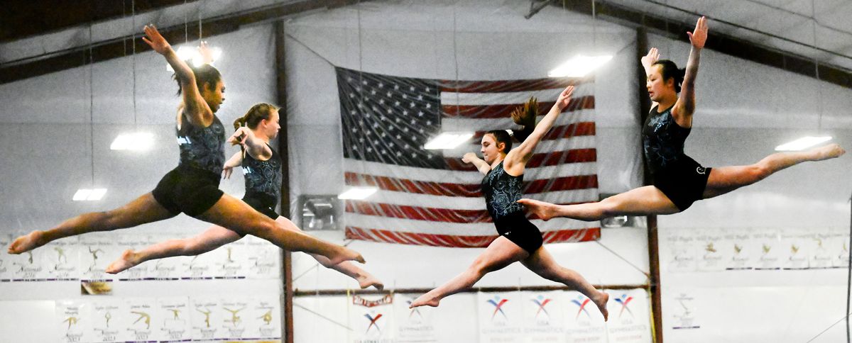 From left, national-meet bound Charlize Hall, Ava Hamilton, Gracie Allen and Tianmei Dwyer take to the air before practice at Dynamic Gymnastics on Friday.  (Kathy Plonka/The Spokesman-Review)