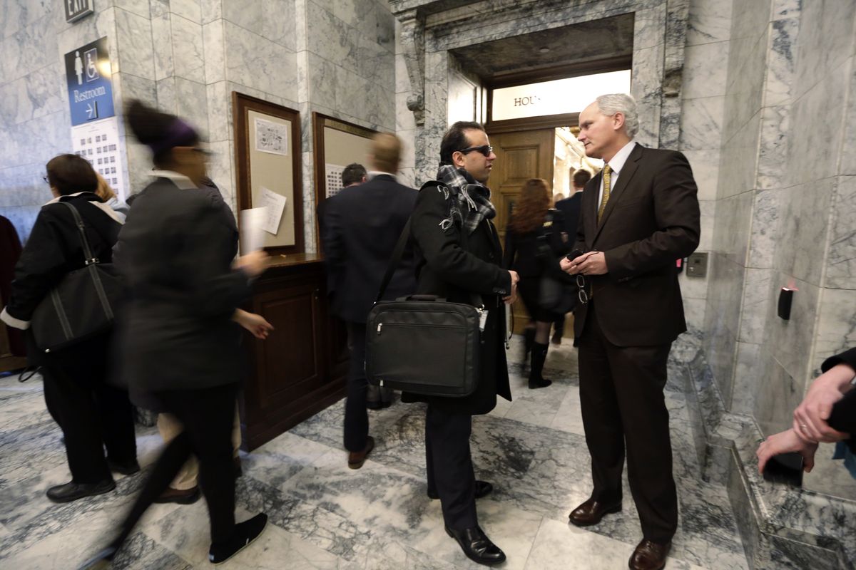 Rep. Cyrus Habib, D-Kirkland, speaks with lobbyist Jim Richards, right, outside the House chambers in Olympia last month. (Associated Press)