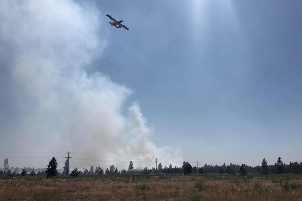 One bulldozer, four fire bosses, one helicopter and two air tankers were involved in fighting the Graham Fire west of Cheney on Wednesday. (Jared Brown, SR)