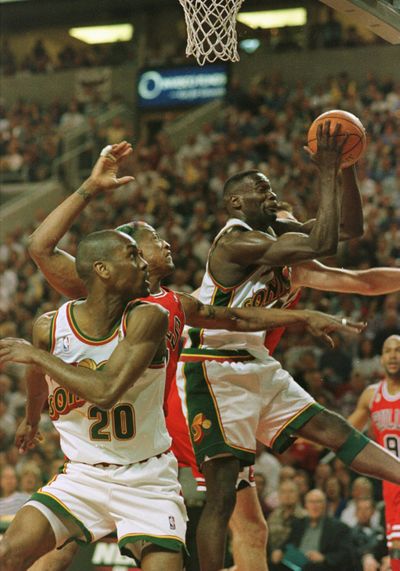 Shawn Kemp of the Seattle Supersonics pulls in an offensive rebound over Dennis Rodman (91) and Luc Longley, back, of the Chicago Bulls as Supersonics teammate Gary Payton (20) looks on during the first half of the fourth game of the NBA Finals, June 12, 1996.    (Jonathan Daniel/Getty Images North America/TNS)