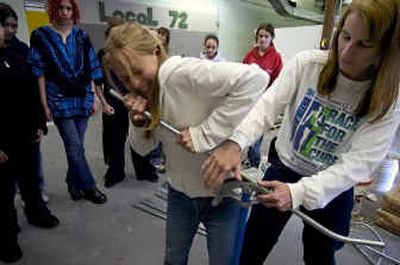 
Coleen Buckham, right, an instructor at the Spokane Community College Apprenticeship Training Center, shows Shaw Middle School eighth-grader, Jessica Caldwell, 14, how to bend electrical conduit. During the field trip, girls from local Spokane middle schools spent the day learning about the construction trades and related career opportunities Thursday.  
 (Colin Mulvany / The Spokesman-Review)