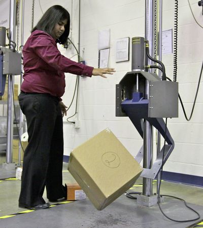UPS packaging engineer Preeti Agrawal tests a packed box using a drop impact tester at the UPS Package Design and Testing Lab in Addison, Ill., on Tuesday. (Associated Press)
