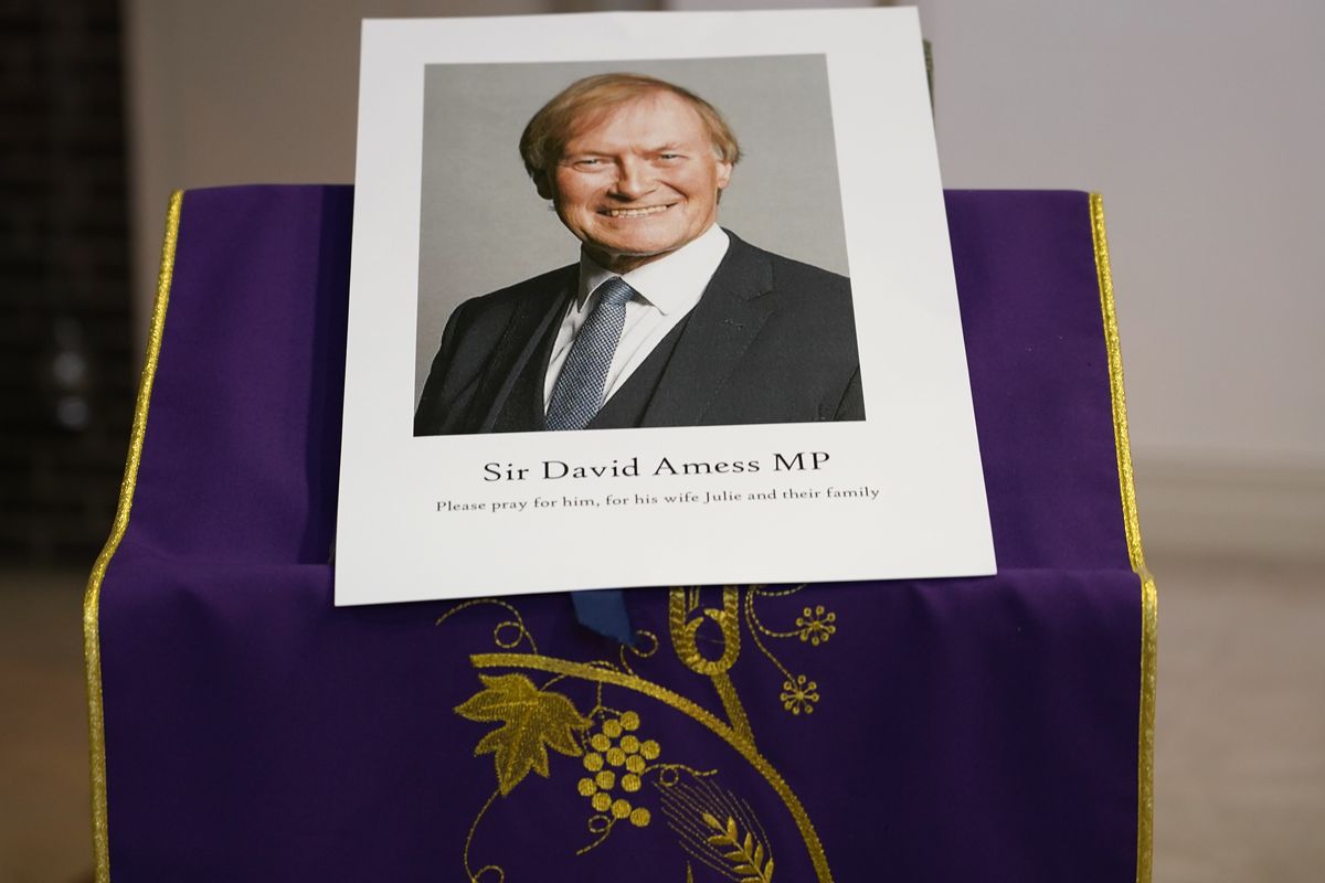 An image of murdered British Conservative lawmaker David Amess is displayed near the altar in St Peters Catholic Church before a vigil in Leigh-on-Sea, Essex, England, Friday, Oct. 15, 2021. Amess died after being stabbed earlier Friday during a meeting with constituents at another nearby church in eastern England. Police gave no immediate details on the motive for the killing of 69-year-old Conservative lawmaker Amess and did not identify the suspect, who was being held on suspicion of murder.  (Alberto Pezzali)
