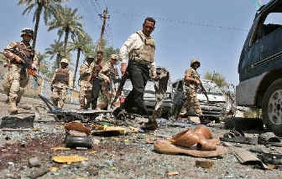 
Iraqi soldiers examine wreckage of cars that were destroyed Friday in an explosion in Baghdad, Iraq. Militants unleashed at least 13 mortar, bomb and suicide car bomb attacks against Iraqi troops and U.S. allies, killing at least 41 people.
 (Associated Press / The Spokesman-Review)