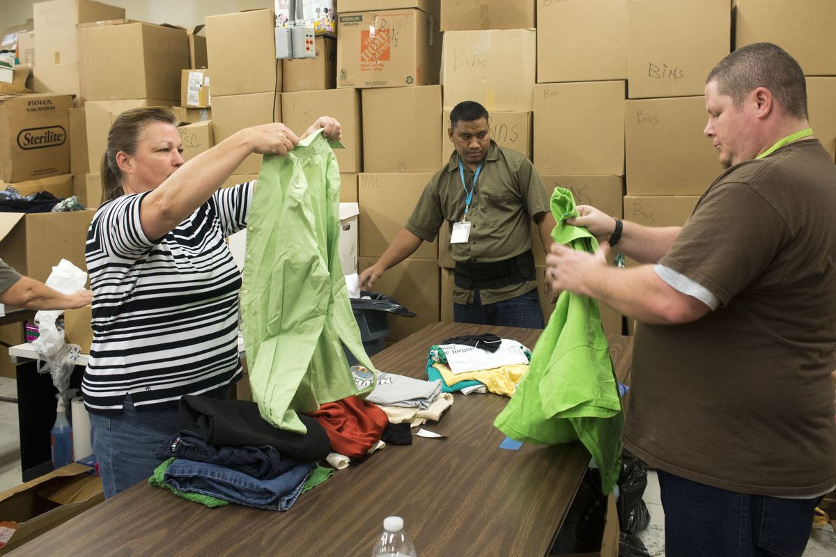 Brita Barsness, Philimon Joel and Shane Jones assess and sort thousands of garments Monday in the back room at the new Arc of Spokane Thrift Store. The new store will provide a revenue stream to the group that serves people with disabilities. (Jesse Tinsley)