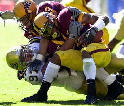 
UCLA defensive tackle C.J. Niusulu, bottom, takes down Arizona State wide receiver Rudy Burgess in the first quarter. 
 (Associated Press / The Spokesman-Review)