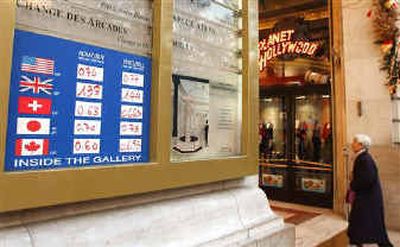 
A woman enters a gallery promoting an exchange office on the Champs Elysees Avenue on Tuesday in Paris. The U.S. dollar dropped Tuesday to a new all-time low against the euro, which rose to $1.3335. 
 (Associated Press / The Spokesman-Review)