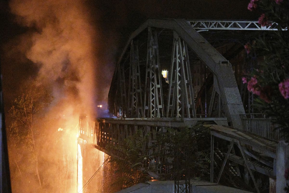 Flames engulf the Industry Bridge in Rome, early Sunday, Oct. 3, 2021. A blaze, possibly sparked by a gas canister explosion, destroyed part of an historic bridge spanning the Tiber River in Rome before firefighters extinguished the flames early Sunday.  (Mauro Scrobogna)