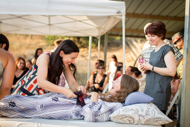 Amanda Friedland, left, surrounded by friends and family adjusts her friend Betsy Davis’s sash as she lays on a bed during her “Right To Die Party” in Ojai, Calif., on July 24, 2016. (Niels Alpert / Associated Press)